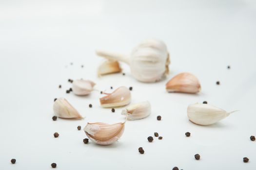 many cloves of garlic on white background,pepper