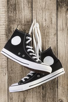 Black sneakers shoes on wooden background