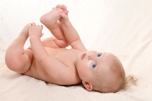 happy baby with a towel after the shower in bed at home