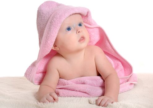 Adorable baby girl, looking out under a pink towel