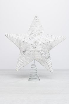 White glittering star shaped Christmas. Ornament on rustic white table background