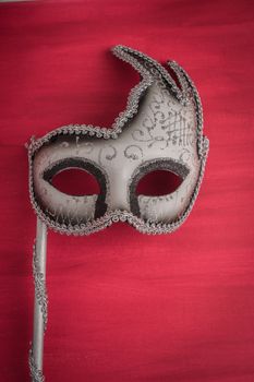 Colorful carnival mask on a red textured background. Masks with theater concept. Top view with copy space