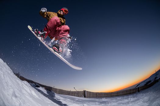 Young man snowboarding in the mountains.