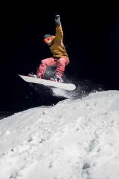 Snowboarder jumping at night.