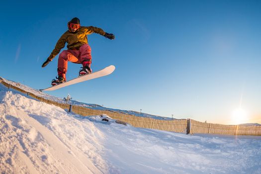 Snowboarder executing a radical jump against blue sky.