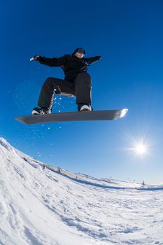 Snowboarder executing a radical jump against blue sky.