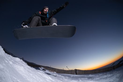 Young man snowboarding in the mountains.