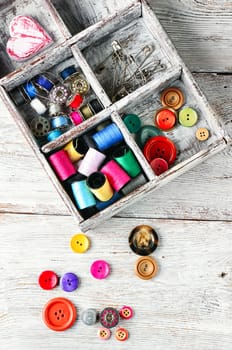 Light wood box with threads,buttons and pins.Top view