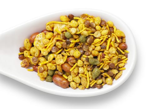 Dry roasted Indian snack mix in a big spoon, isolated