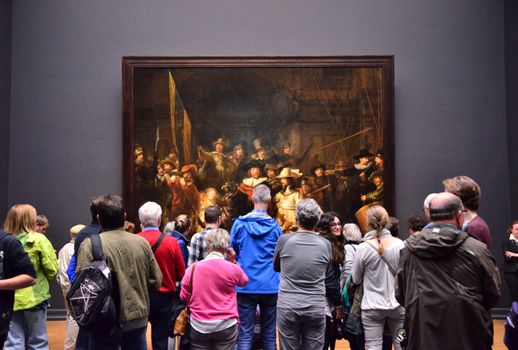 Amsterdam, Netherlands - May 6, 2015: Visitors at the famous painting "Night watch" at Rijksmuseum, Amsterdam, Netherlands. The Rijksmuseum is dedicated to arts and history in Amsterdam.