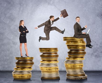 Business people on coins on grey wall background, business concept