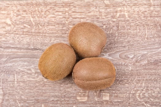 Ripe kiwi on a brown wooden background