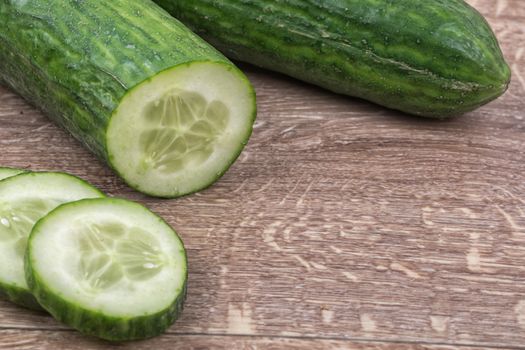 Cucumbers on a brown wooden background