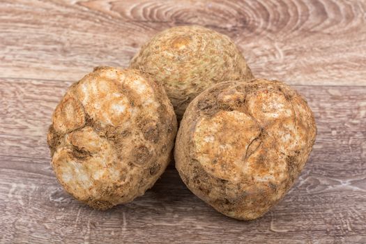 Three celery on a brown wooden background