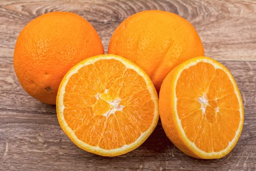 The orange oranges on a brown wooden background
