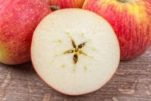 Ripe apples on a brown wooden background