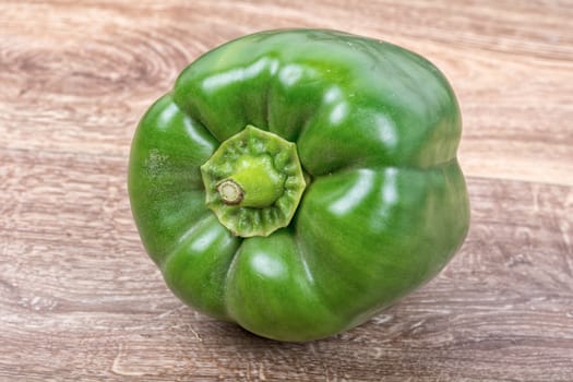 Green peppers on a brown wooden background