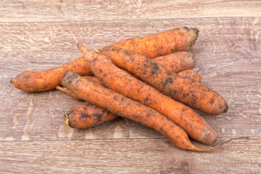 Red carrots on a brown wooden background