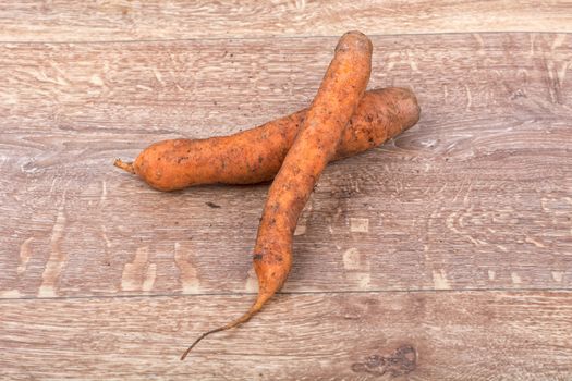 Red carrots on a brown wooden background