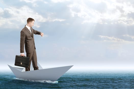 Businessman in paper boat in blue sea, business concept
