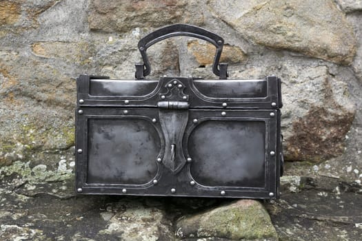 Nice forged chest on stone wall.