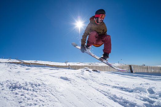 Snowboarder executing a radical jump against blue sky.