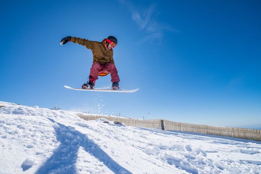 Snowboarder executing a radical jump against blue sky.