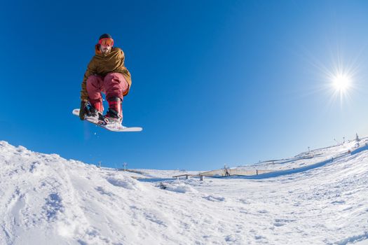 Snowboarder executing a radical jump against blue sky.