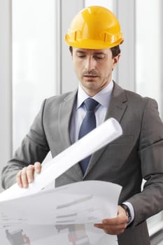 Architector in hardhat and business suit with construction plans