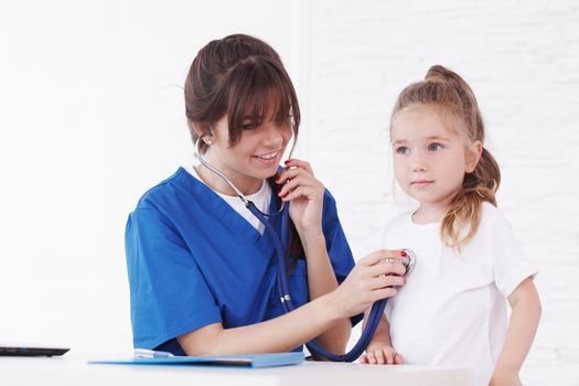 Young smiling female doctor and her little patient 