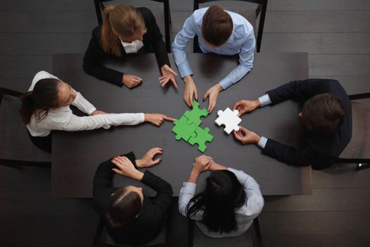 Group of business people assembling jigsaw puzzle, team support and help concept