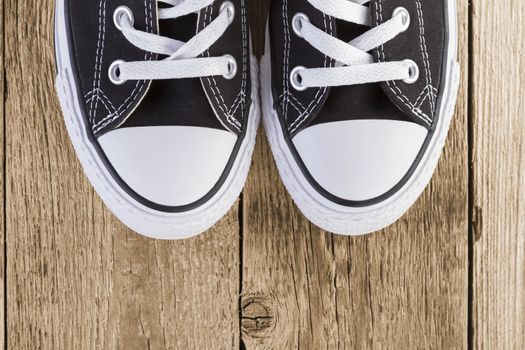 Black sneakers shoes on wooden background