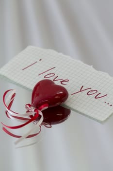 red heart with ribbon and love on a white background