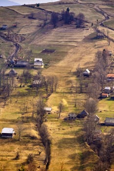 Sunny spring in mountain village. Carpathian fields and hills