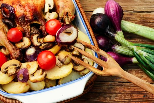 Dish with baked chicken potato with fresh vegetables.Photo tinted