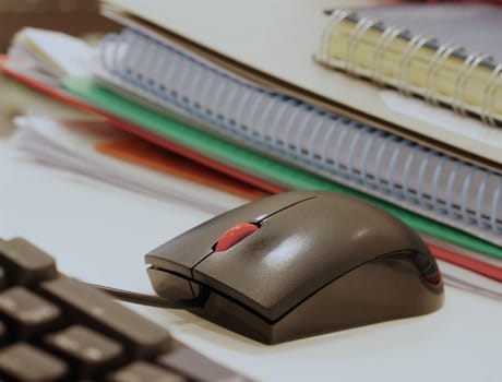 Document, work report and computer device on desk at office.