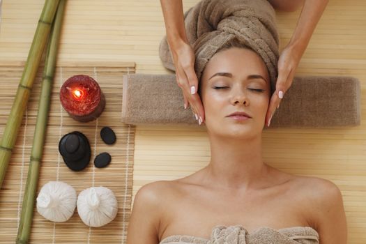 Beautiful young woman relaxing in spa salon