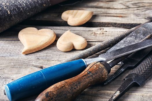 Symbolic wooden hearts cut by hand and carpenter tools