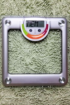 Floor scales on the glass against the green carpet