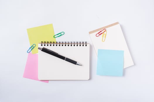 Opened notebook with blank space for text or message, sticky paper, and pen on office table