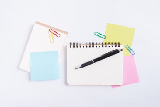 Opened notebook with blank space for text or message, sticky paper, and pen on office table