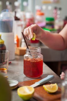 The process of making Thai lemon tea. Woman right hand squeeze lemon into cold tea