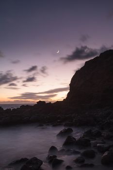 Moonset and sunset at Crescent Bay beach in Laguna Beach, California, United States