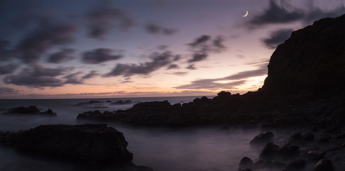Moonset and sunset at Crescent Bay beach in Laguna Beach, California, United States