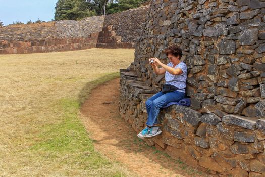 A woman taking a photo at the yacatas in Tzintzuntzan, Michoacan, Mexico