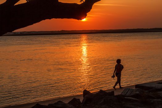 A woman walks along the shore of a lagoon in St. Augustine, Florida