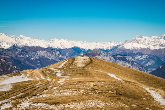 The spring sun warms the mountains with meadows still partially covered with snow.