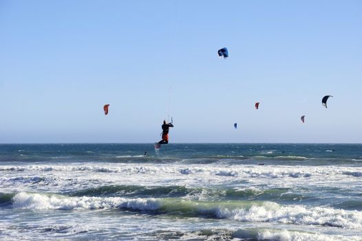 Several kitesurfers on Pacific coast.