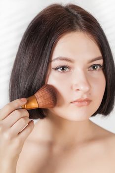 the girl does make-up on a white background