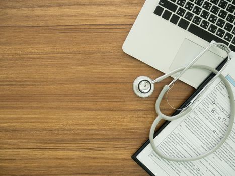 desk' doctor with computer, stethoscope, medical record application form. top view